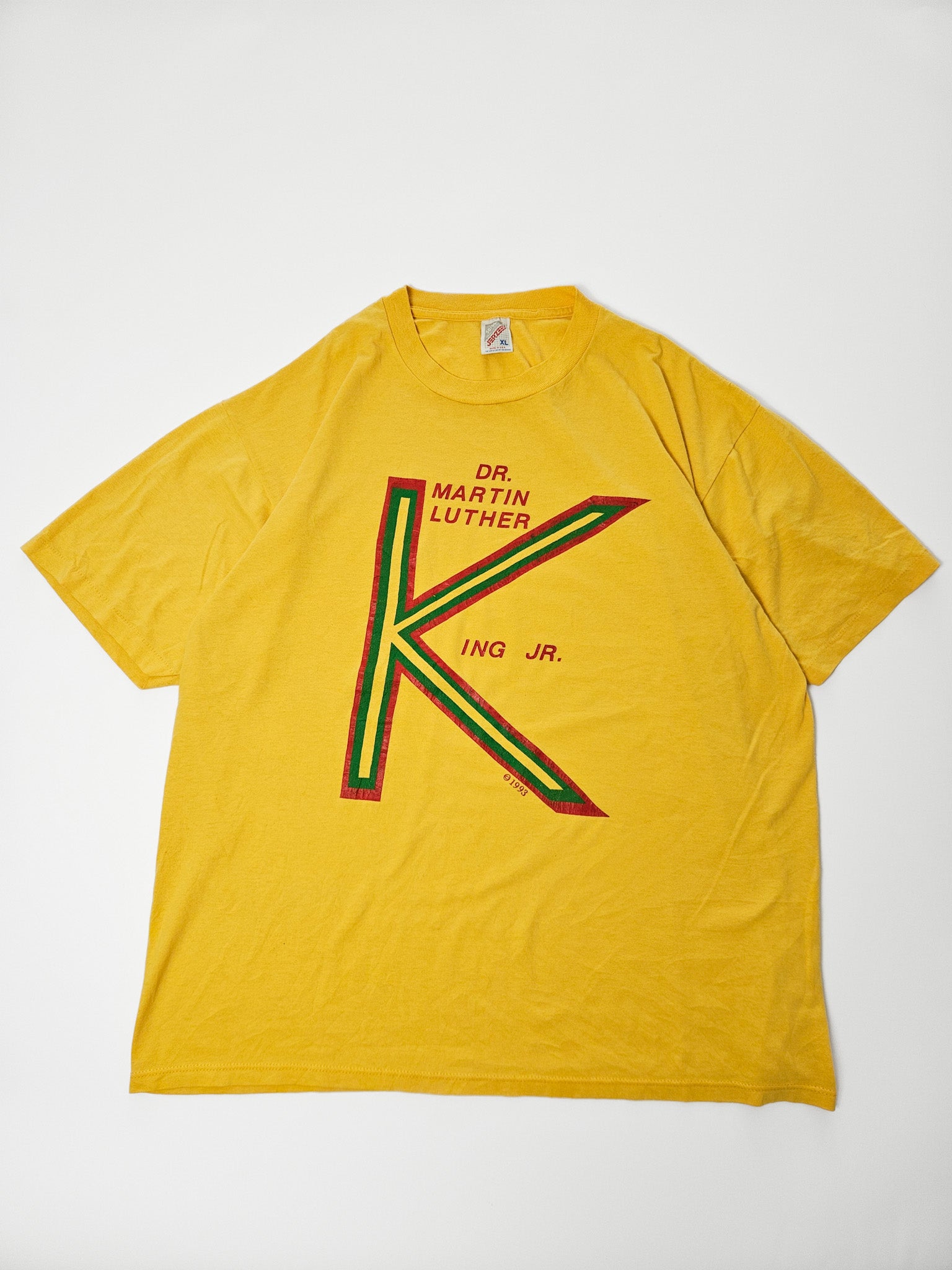 Vooraanzicht van geel 1993 MLK Jr. T-shirt met grote grafische K in rood, geel en groen