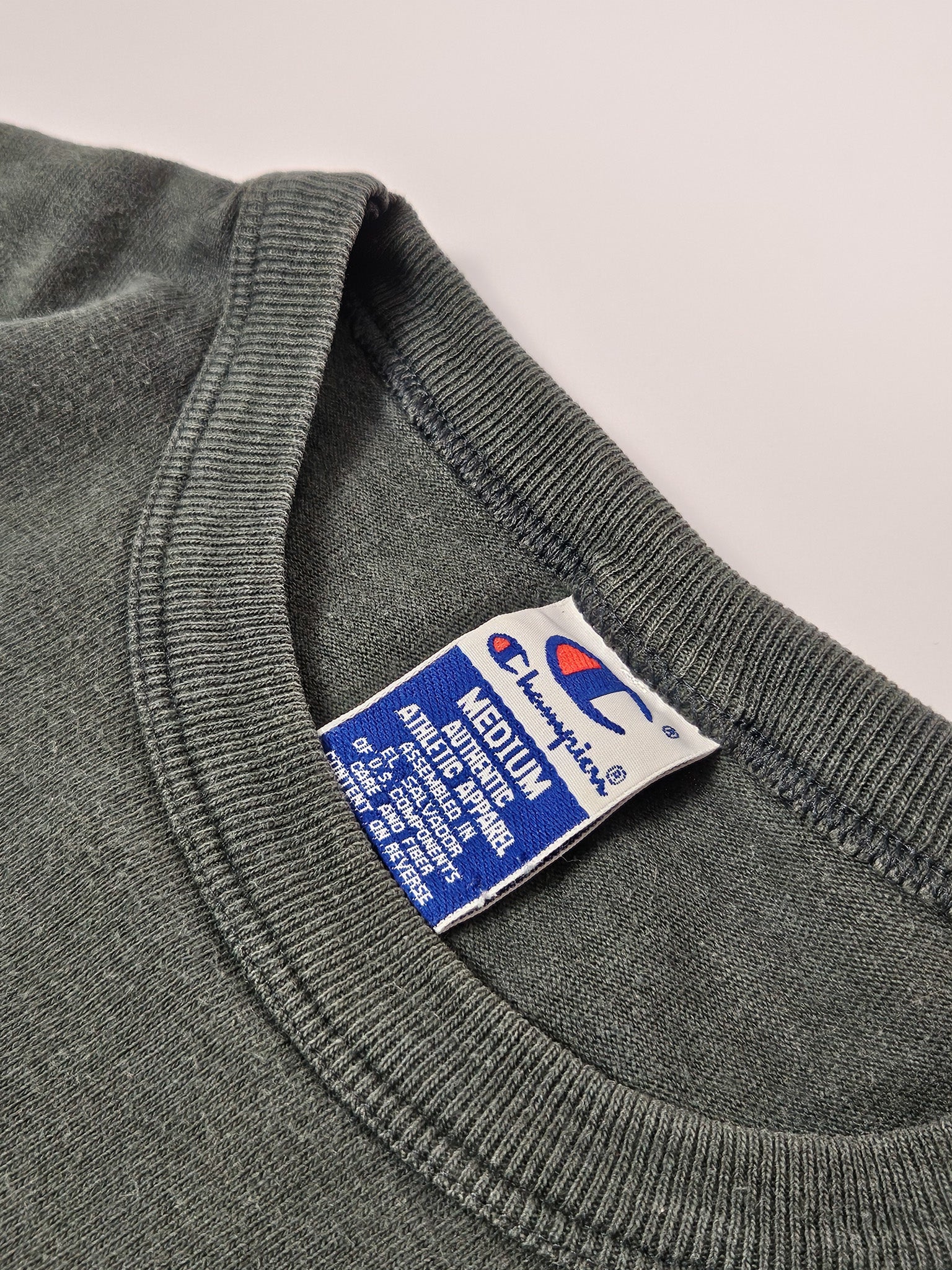 Close-up van het blauwe Champion label met maat M uit de jaren 90
