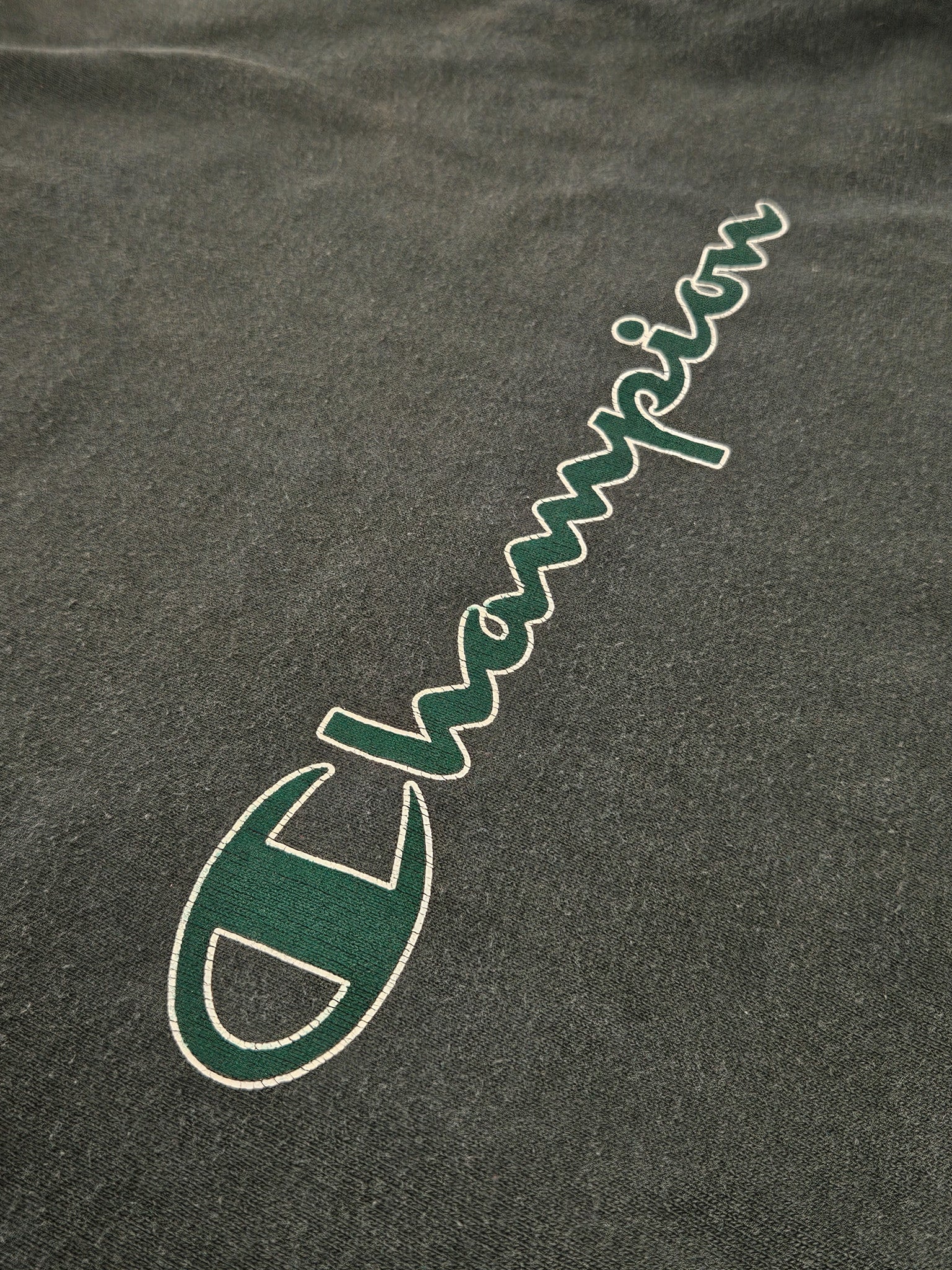 Close-up van het Champion script logo op de borst met craquelé print
