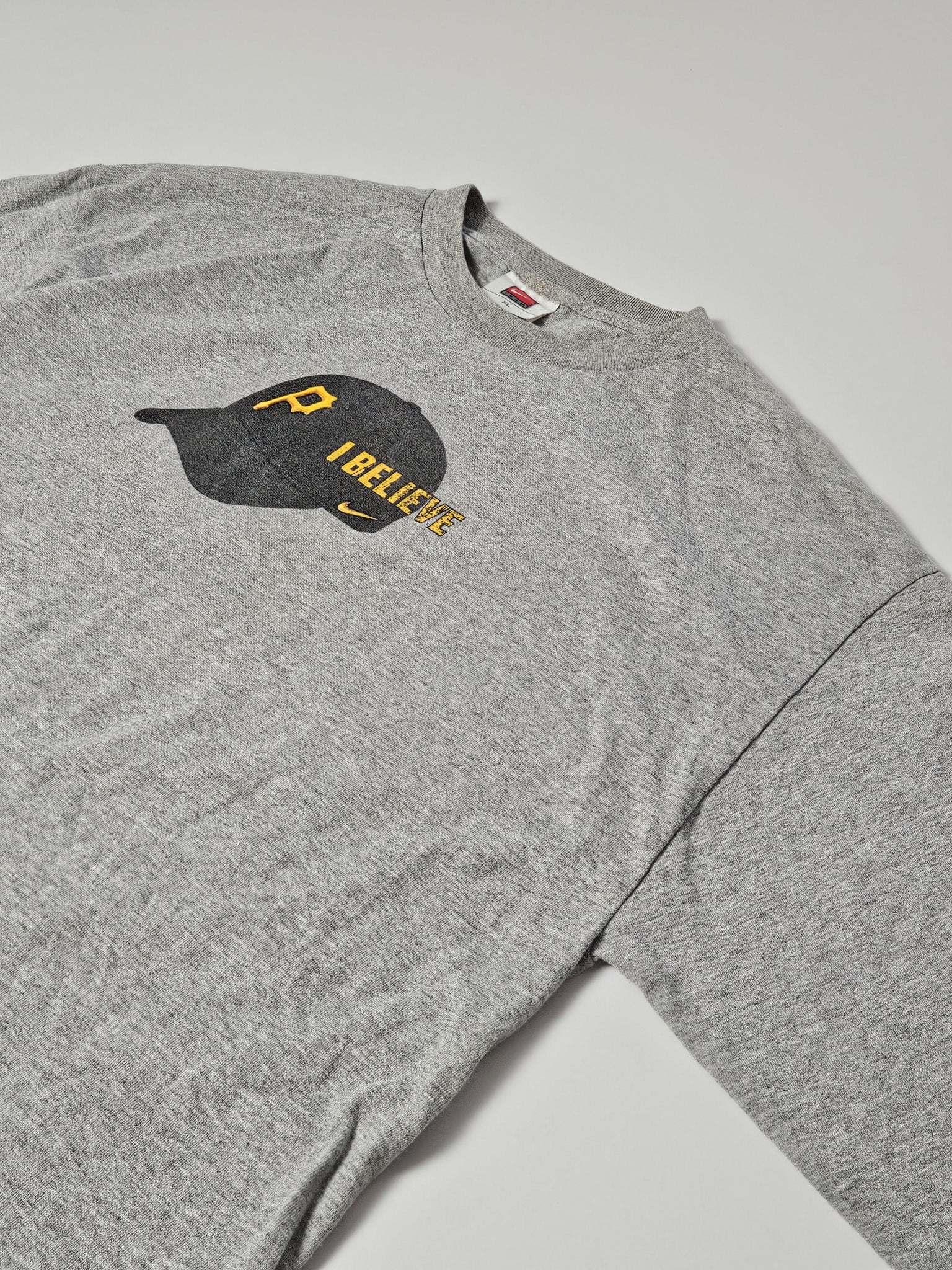 Grijze Nike longsleeve met Pittsburgh Pirates pet en “I BELIEVE” print op de borst, maat XL
