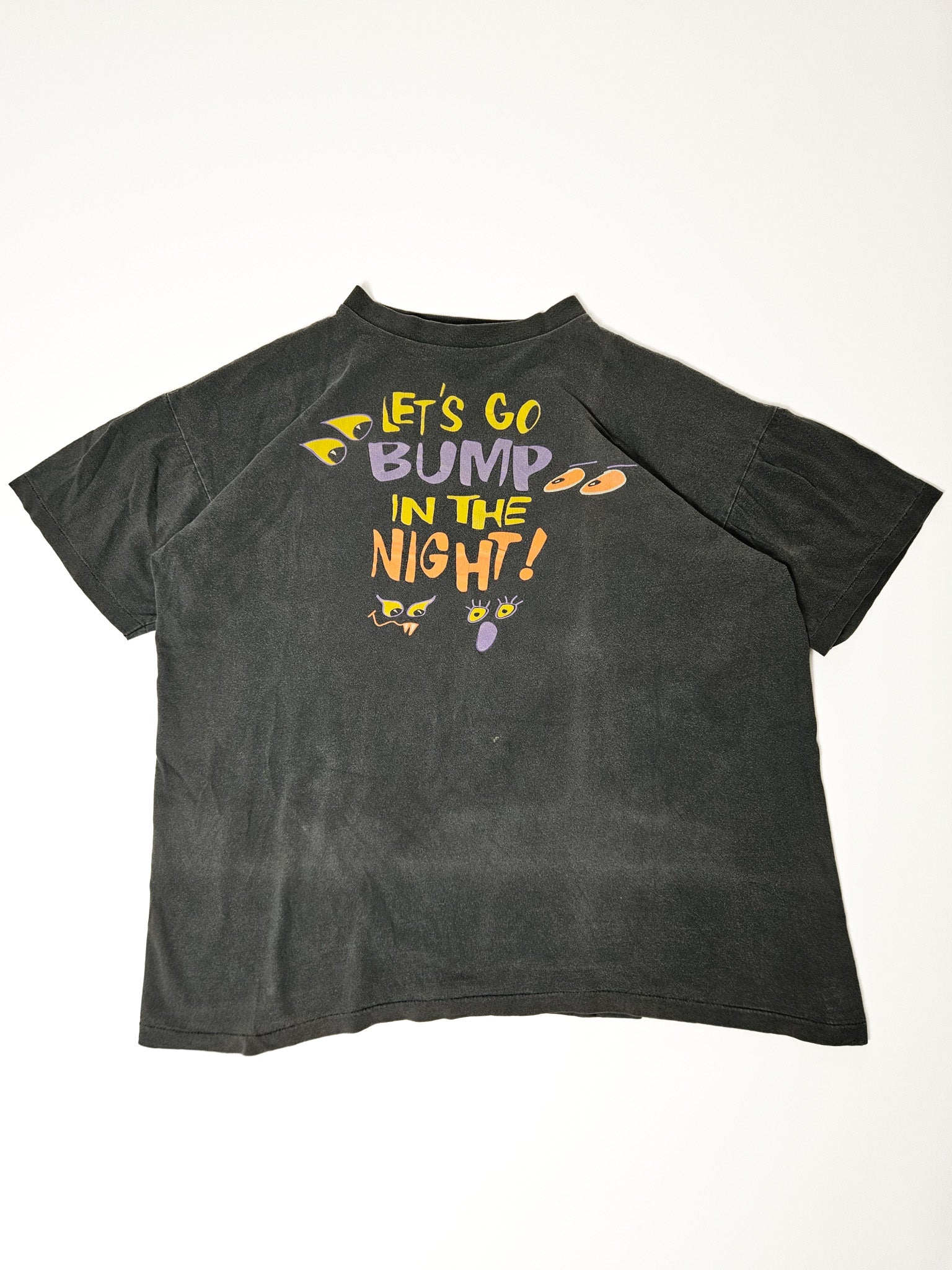 Donkergrijs vintage T-shirt met "Let's Go Bump in the Night" print op flat lay
