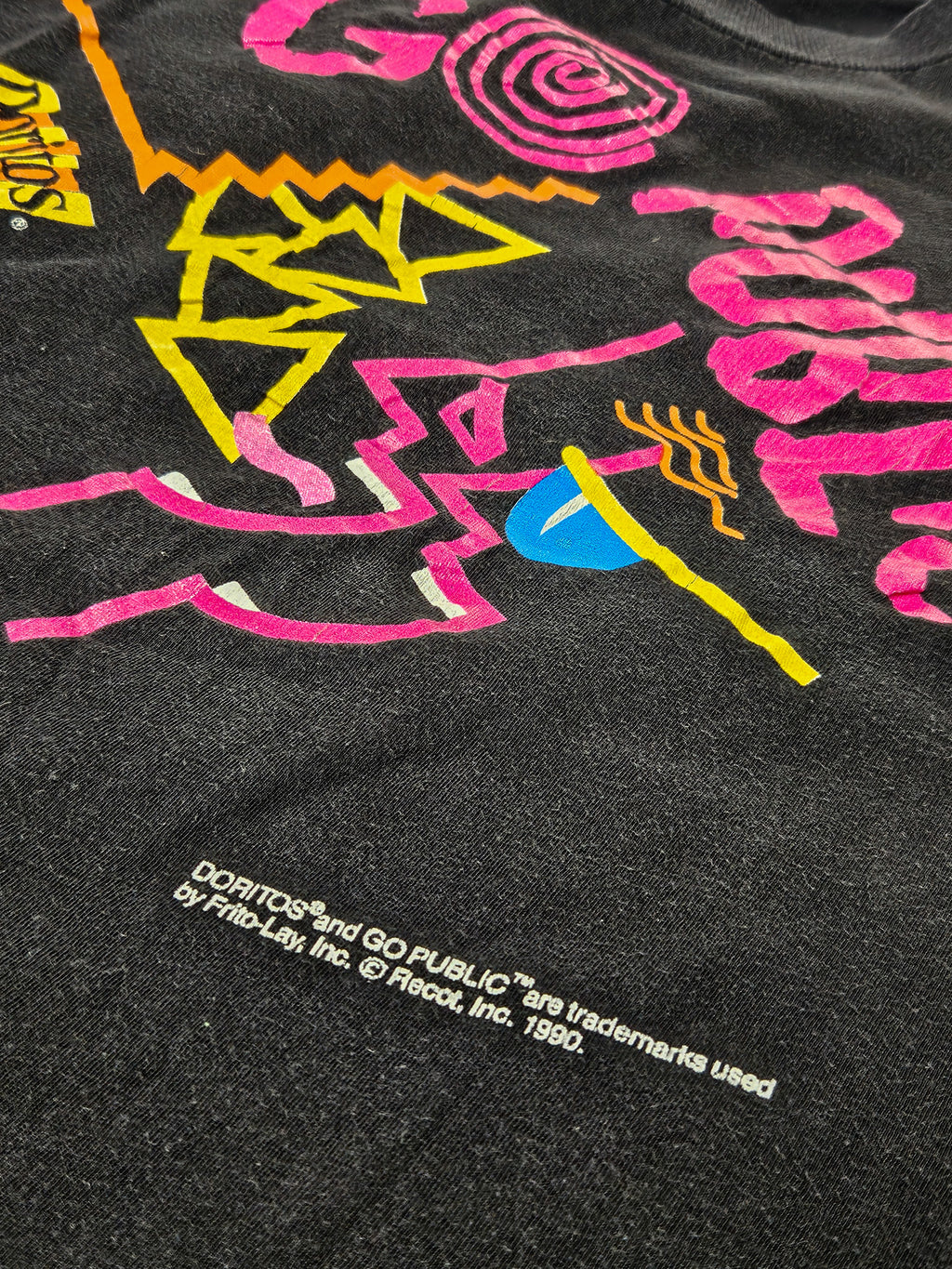Detail van de felgekleurde abstracte graphic print op het vintage Go Public T-shirt