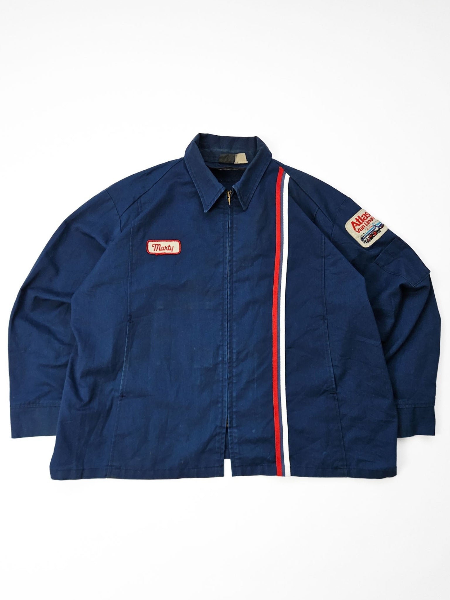 Volledige flatlay 1970s Atlas Van Lines vintage racing stripe work jacket met patch en naamlabel