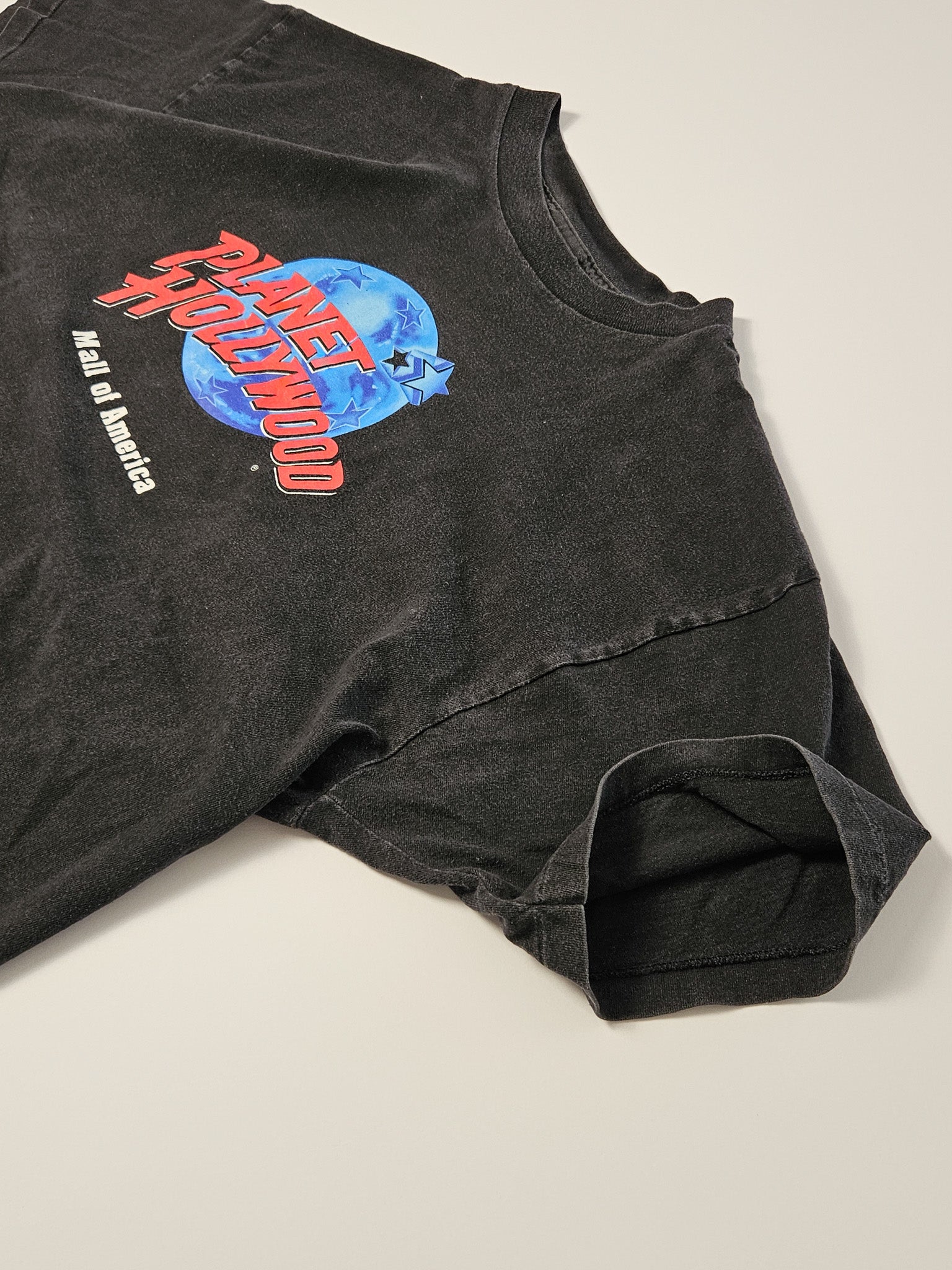 Zwart vintage Planet Hollywood T-shirt uit de jaren 90 met blauw-oranje globe logo van Mall of America op de borst