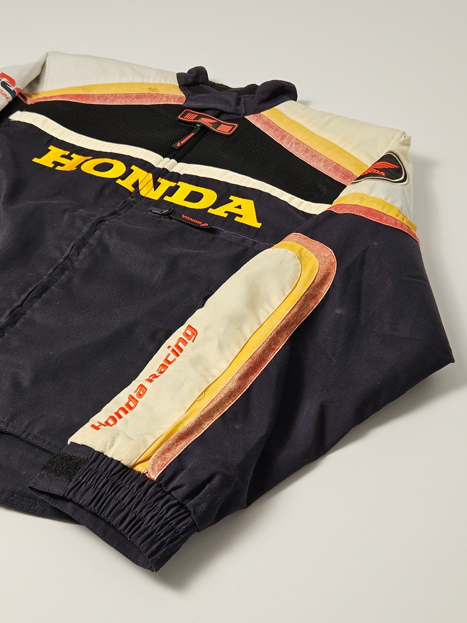 Vintage Honda Racing jas uit de jaren 90, gedragen op circuits in Japan, met geborduurd logo en ritssluiting

