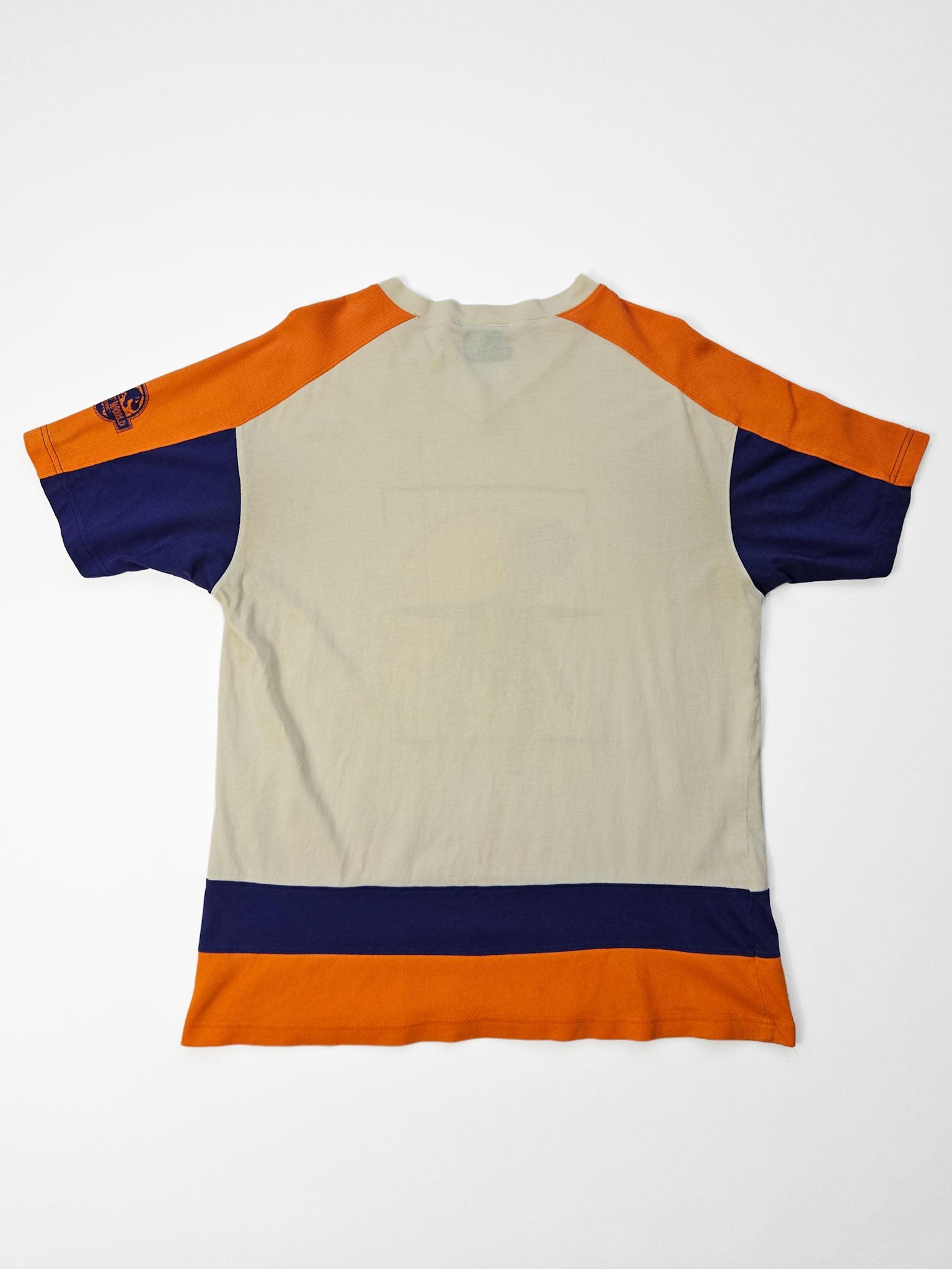 Lost World-logo in blauwe zeefdruk op oranje mesh mouwpaneel