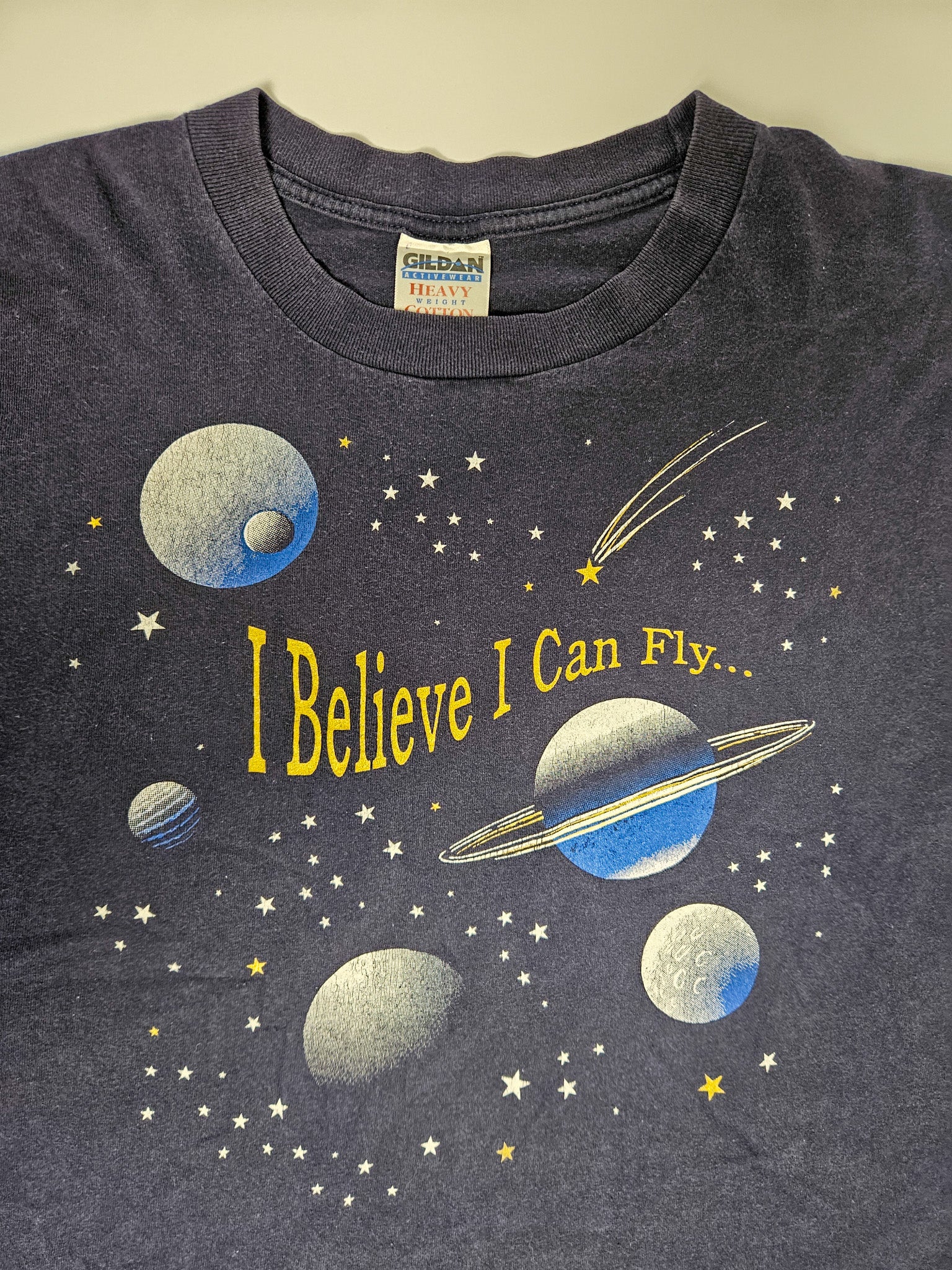 Detail van de sterren en Saturnus planeet op het vintage I Believe I Can Fly T-shirt