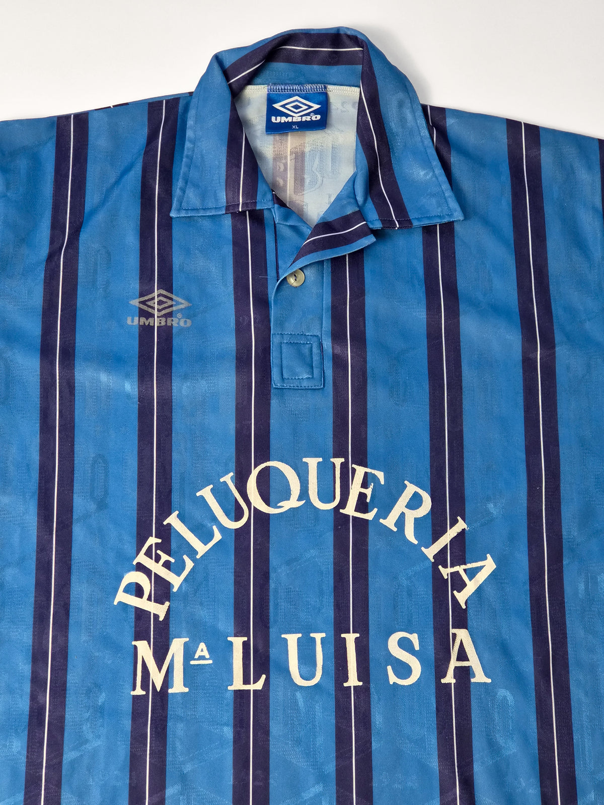 Vintage Umbro voetbalshirt uit de jaren '90 in blauw met gestreepte all-over print en Peluquería Maluisa borstprint.