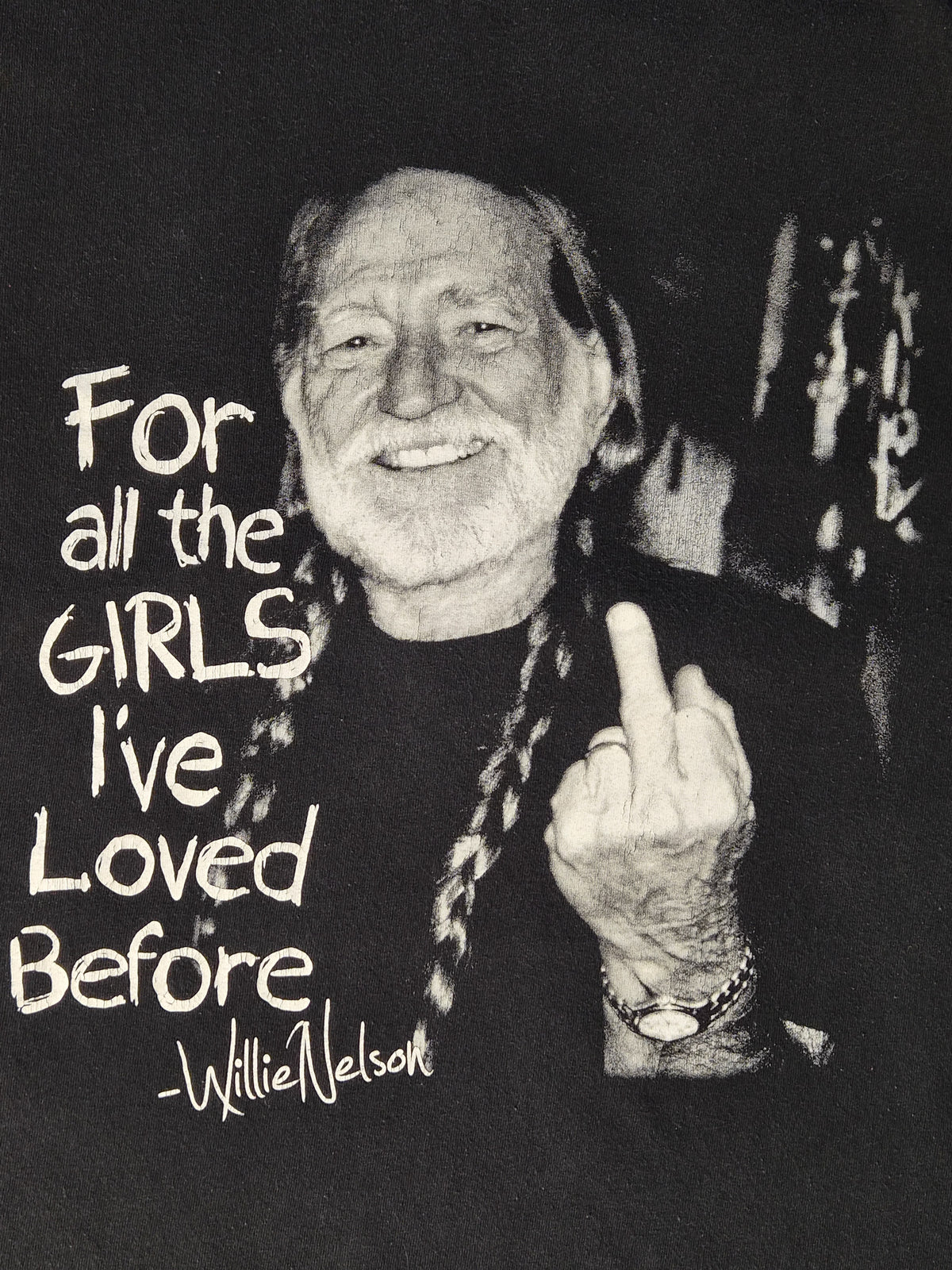 Vintage Willie Nelson T-shirt uit circa 2000 in faded zwart met For All the Girls I've Loved Before middle finger graphic.